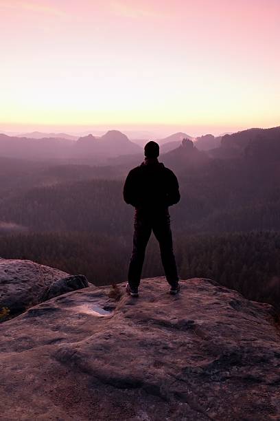 istock Tall man watch to mountain sunrise.Silhouette in selfconfident pose 532952568