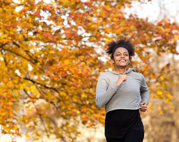 istock Happy young woman running outdoors in the park 532955659