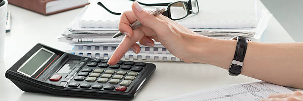 close-up da mulher fazendo cálculos contador ou banqueiro - tax tax form finance small business - fotografias e filmes do acervo