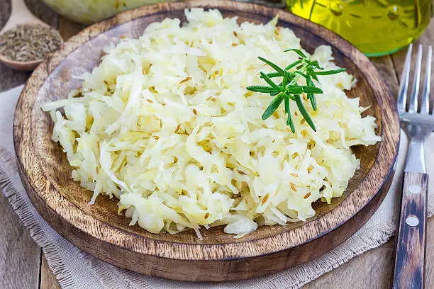 Homemade sauerkraut on a wooden plate, closeup