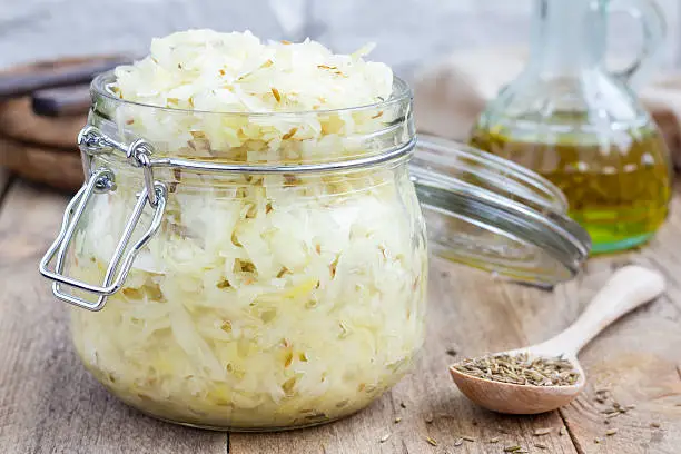Homemade sauerkraut with cumin in a glass jar, closeup