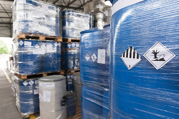 Environmental hazard barrels Waste barrels with hazard warning symbols in the warehouse drum container stock pictures, royalty-free photos & images