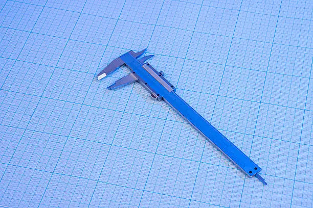 Vernier-caliper on graph paper under blue light
