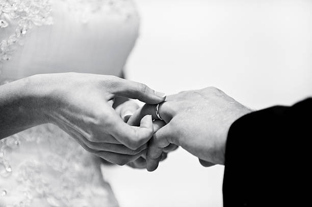 istock Bride putting Wedding Band on Groom 532958923