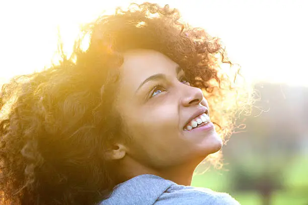 Photo of Young african american woman smiling and looking up