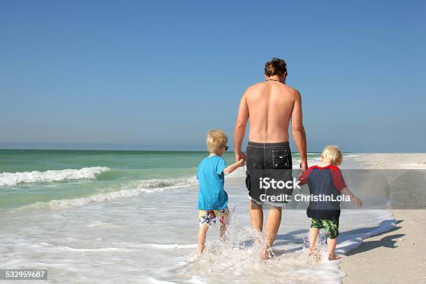 Father And Sons Holding Hands Walking Through Ocean Stock Photo - Download Image Now