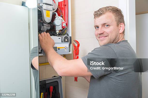 Technician Repairing Gas Furnace Stock Photo - Download Image Now - Furnace, Natural Gas, Installing