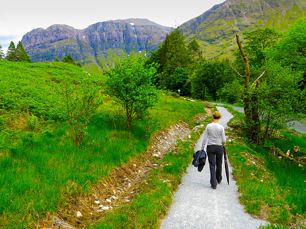 istock One Woman Walking on Path Towards Glencoe, Scotland 532965930