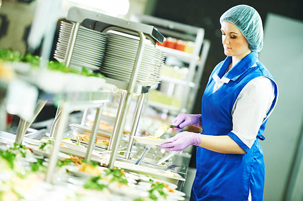 manutenzione operaio femminile a a buffet cibo nella caffetteria. - cafeteria foto e immagini stock