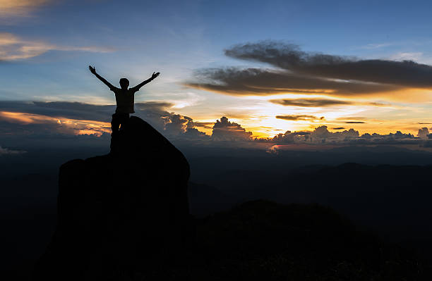 istock Man standing on giant rock and spreading hand on mountain 532967952
