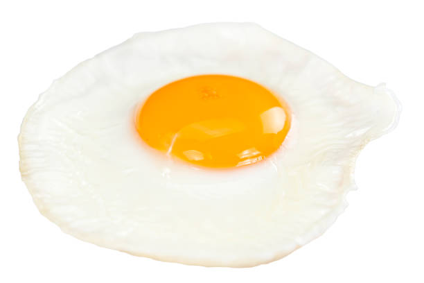 Fried Egg isolated on white Fried Egg isolated on white background (close-up shot) egg yolk on white stock pictures, royalty-free photos & images