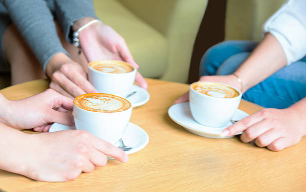 istock Three girls holding their coffee cups in cafe 532971106