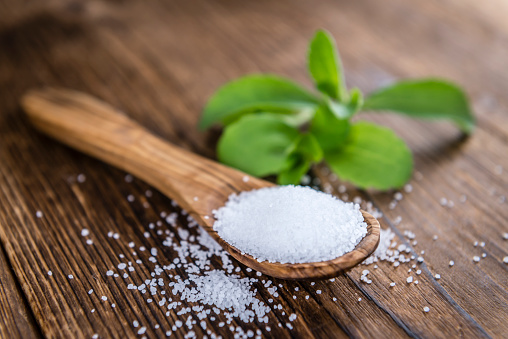 Old wooden table with Stevia Granules (selective focus; close-up shot)