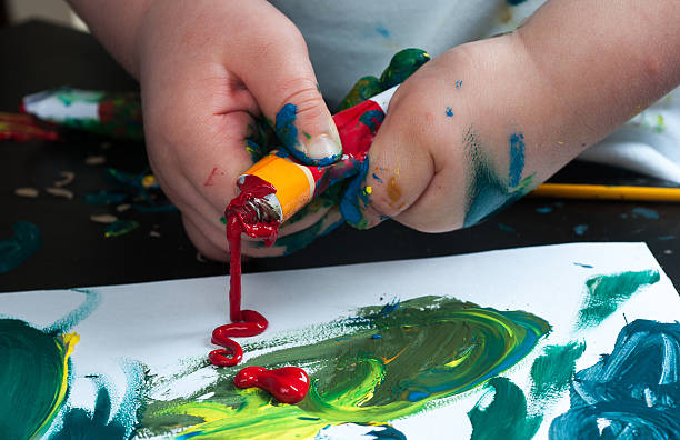 istock Squeezeing tube of acrylic paint by child 532976310