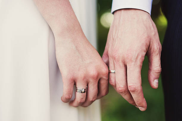istock Closeup of bride and groom holding hands 532976394