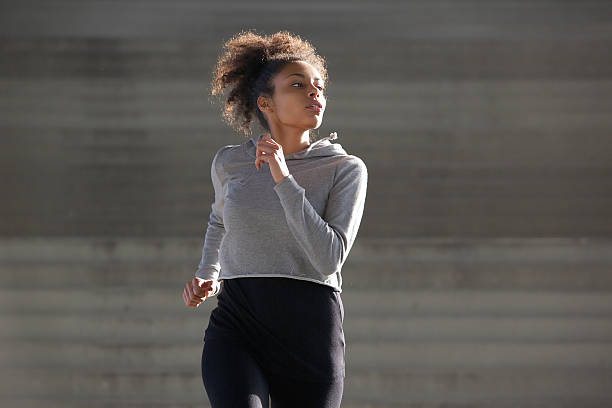 istock Young woman jogging outside in urban environment 532980695