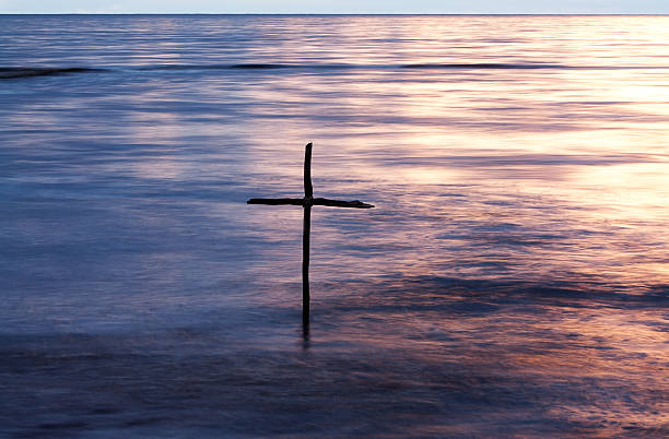 Baptism symbol of Baptism, a wooden cross in the Jordan River rood stock pictures, royalty-free photos & images