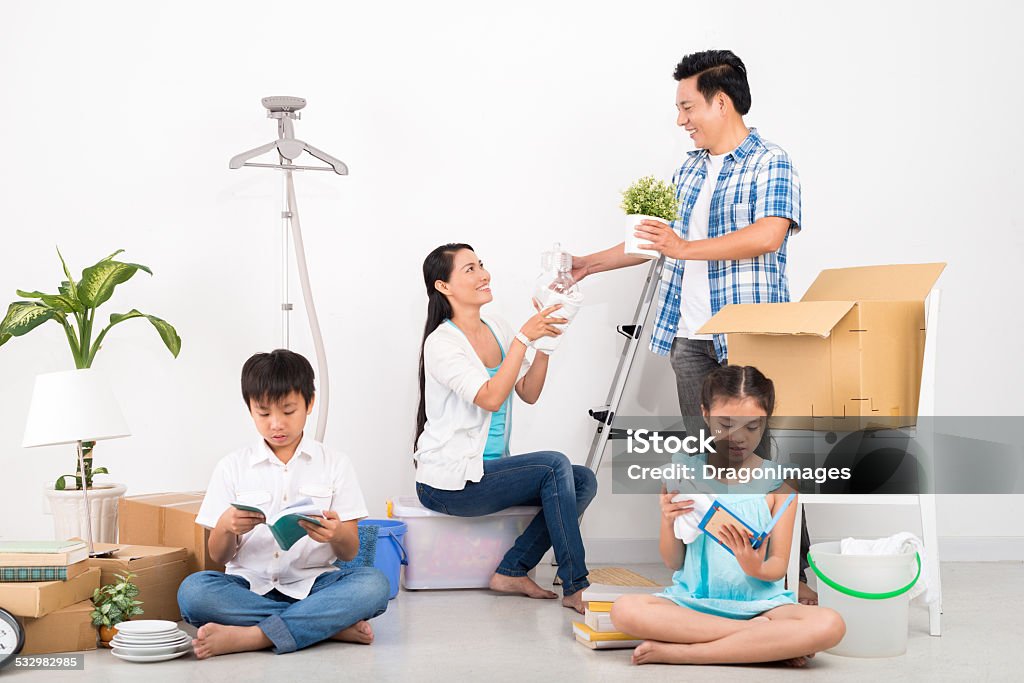 Unpacking Vietnamese family unpacking cardboard boxes in their new house 2015 Stock Photo