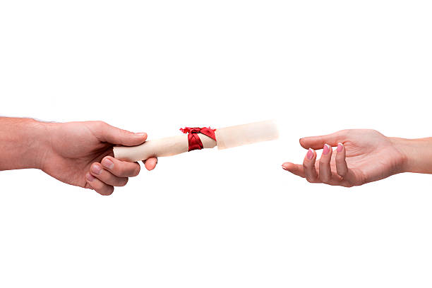 istock Hand giving rolled parchment with ribbon 532983501