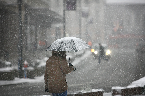 Hombre con paraguas durante la tormenta de nieve photo