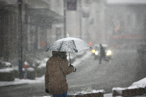 Man with umbrella during snow storm