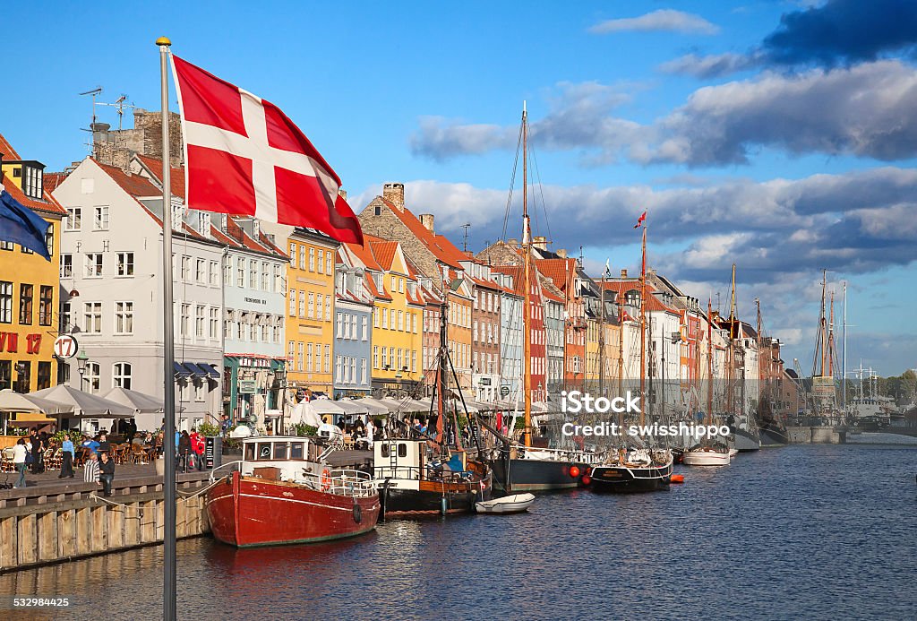 Copenhagen (Nyhavn district) in a sunny summer day COPENHAGEN, DENMARK - AUGUST 25: Unidentified people enjoying sunny weather in open cafees of the famous Nyhavn promenade on August 25, 2010 in Copenhagen, Denmark. Nyhavn district is one of the most famous landmark of Copenhagen popular amoung turists and local people. Copenhagen Stock Photo