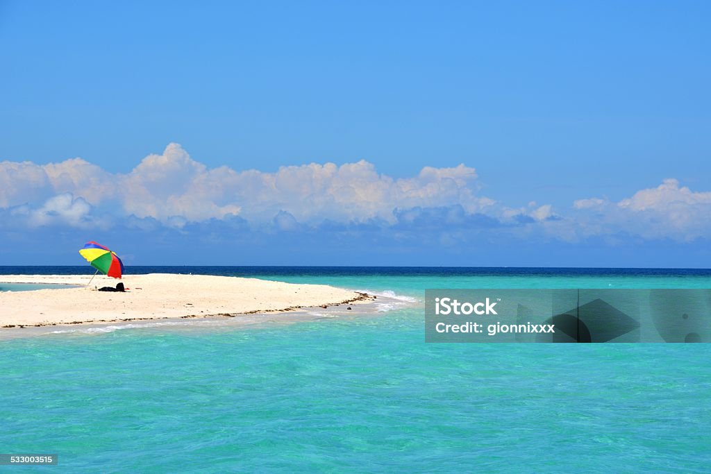 Idyllic white Island, Camiguin - Philippines lonely Parasol on White Island, an uninhabited white sandbar located off the northern shore of Mambajao in Camiguin island, Philippines.  2015 Stock Photo