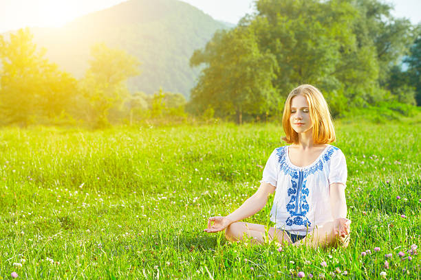 istock young woman doing yoga on green grass 533008237
