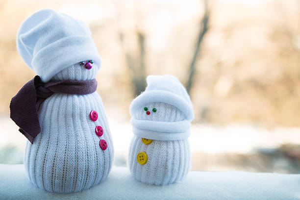 A snowman in a striped hat and scarf on a black background