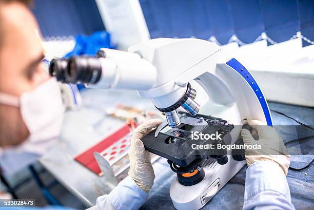 Chemist Researcher Working With Microscope For Forensic Evidence Stock Photo - Download Image Now