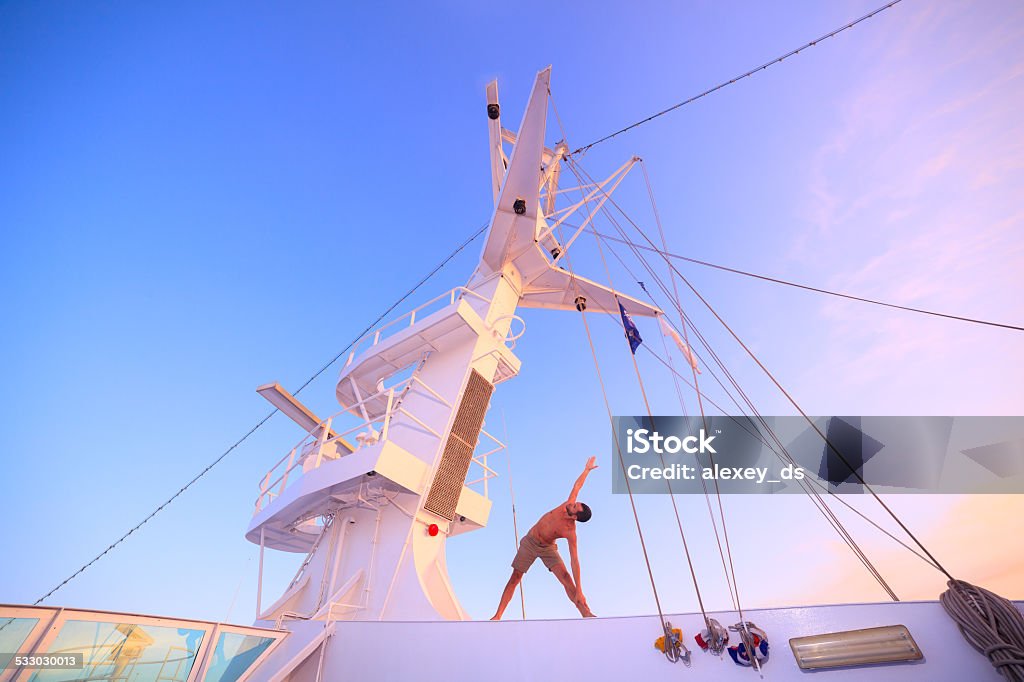 Yoga on ship in the  morning - utthita trikonasana 2015 Stock Photo