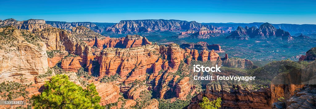 Arizona red rock country panoramic view over Sedona mesa USA The iconic canyons and buttes of Sedona's Red Rock country from high on Bear Mountain overlooking the Ponderosa forests and mesas below, Arizona, USA. ProPhoto RGB profile for maximum color fidelity and gamut. 2015 Stock Photo