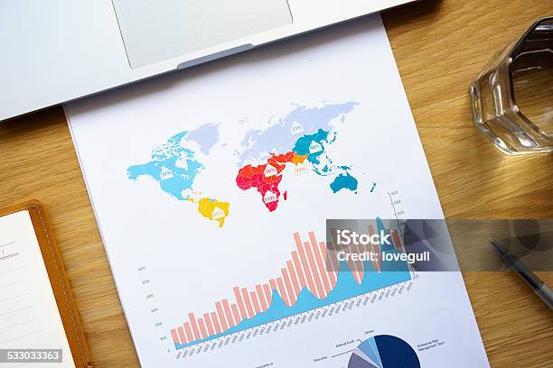 World Finance Chart On Table With Laptop And Office Supplies Stock Photo - Download Image Now
