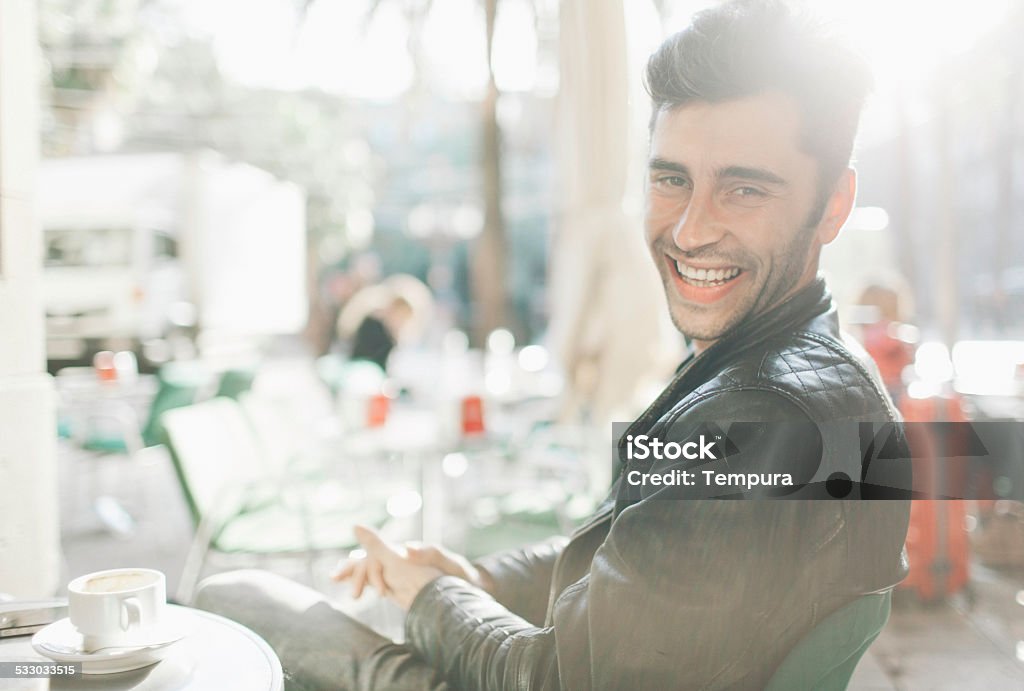 Young man sitting outdoors drinking coffee. More files of this series and models on port. Young man enjoying a coffee in a Spanish bar. Lifestyle. 2015 Stock Photo