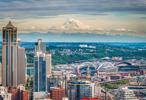 Aerial view over the skyscrapers and landmarks of downtown Seattle, overlooked by the iconic snow capped pyramid of Mt. Rainier (14,411ft). ProPhoto RGB profile for maximum color fidelity and gamut.