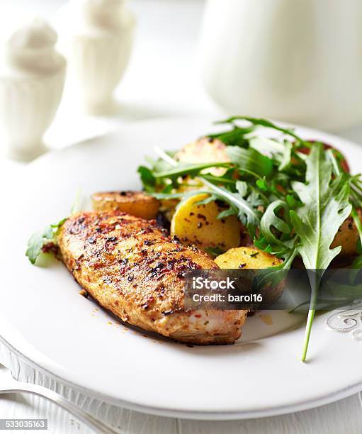 Spiced Chicken Breast With Baked Potatoes And Arugula Stock Photo - Download Image Now