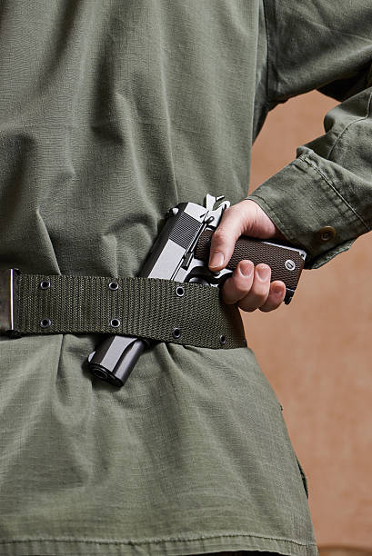 istock Soldier in uniform holding gun in his belt 533035931
