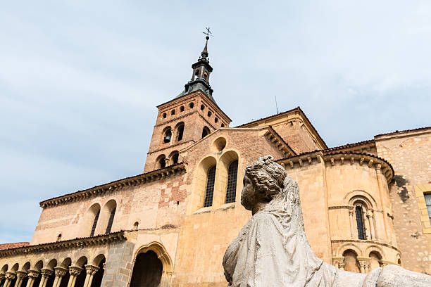 Side view of San Martin Church in Segovia, Spain, a Catholic temple erected in the XII century inside the city walls. Shallow DOF, focus on statue.