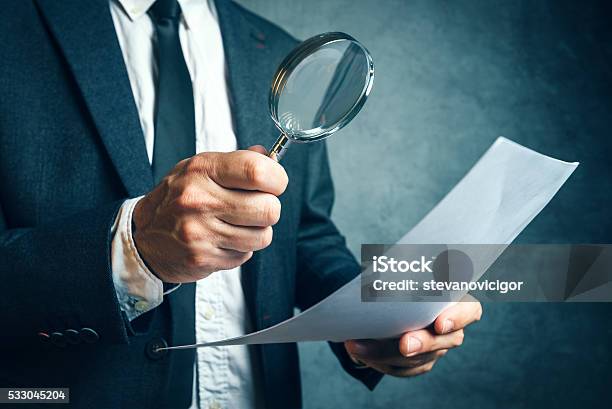 Tax Inspector Investigating Financial Documents Through Magnifyi Stock Photo - Download Image Now