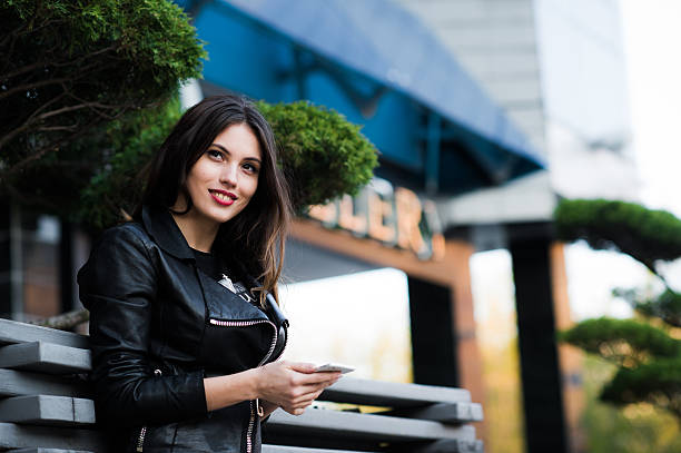 istock Woman walking and using a smart phone in the street 533048784