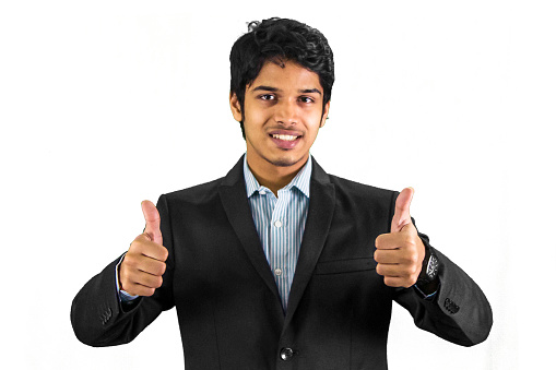 Cheerful young middle eastern businessman showing thumb up isolated over grey background