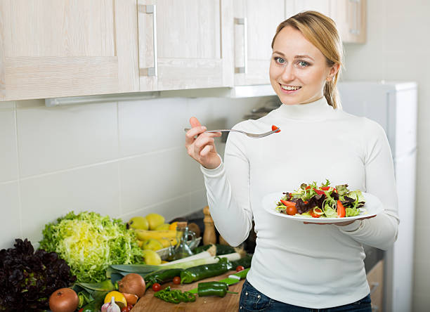 istock Happy girl with vegetable salad in kitchen 533051080