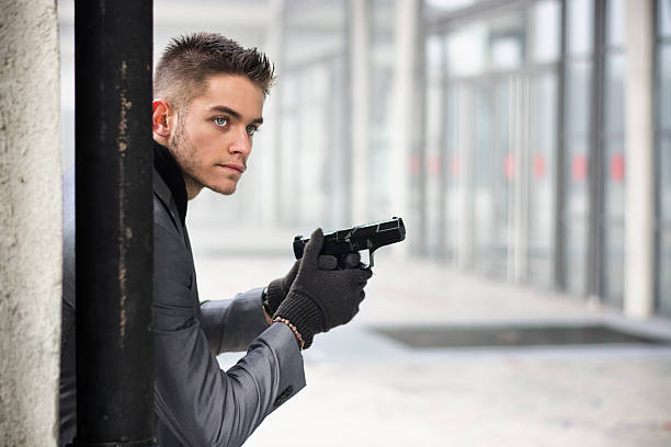 istock Young detective, policeman or mobster in an urban setting holding 533051269