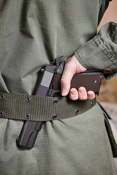 istock Soldier in uniform holding gun in his belt 533051421