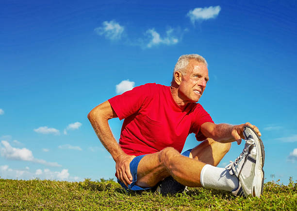 Senior Man In Pain While Stretching Leg On Meadow Full length of senior man in pain while stretching leg on meadow hamstring injury stock pictures, royalty-free photos & images