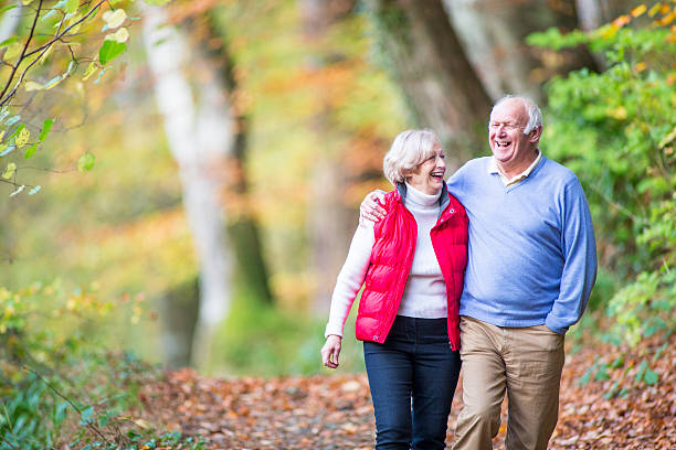 sênior casal na floresta - couple mature adult action walking - fotografias e filmes do acervo