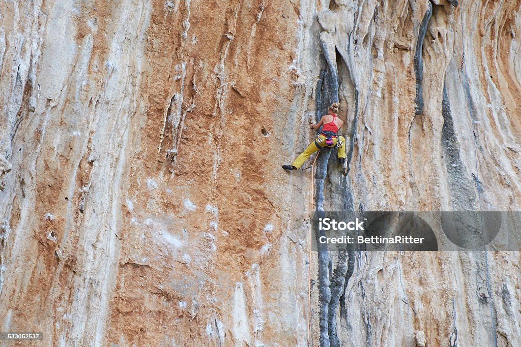 Climbing Young woman climbing a limestone cliff in Kaylmnos / Greece. 2015 Stock Photo
