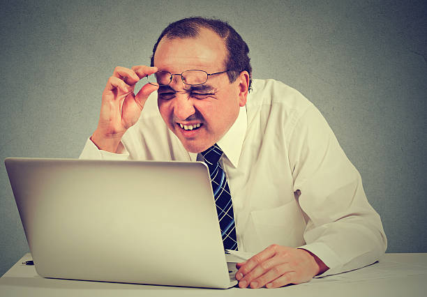 business man with glasses having eyesight problems Closeup portrait middle aged business man with glasses having eyesight problems confused with laptop software isolated on gray background. Age related changes. Human face expression . squint eyes stock pictures, royalty-free photos & images