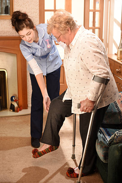 home visit physio young care nurse listens to senior patient in her house artificial knee photos stock pictures, royalty-free photos & images