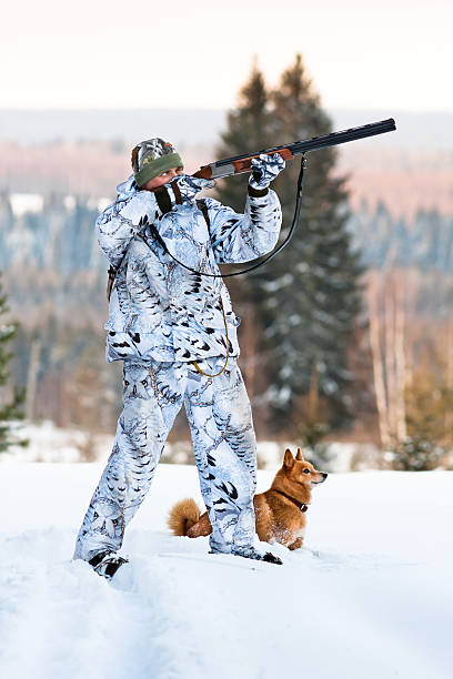 hunter with Finnish Spitz in winter hunter with dog on winter hunting finnish spitz stock pictures, royalty-free photos & images